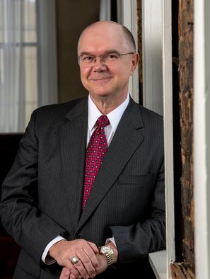 A man in a suit and tie standing next to a door.